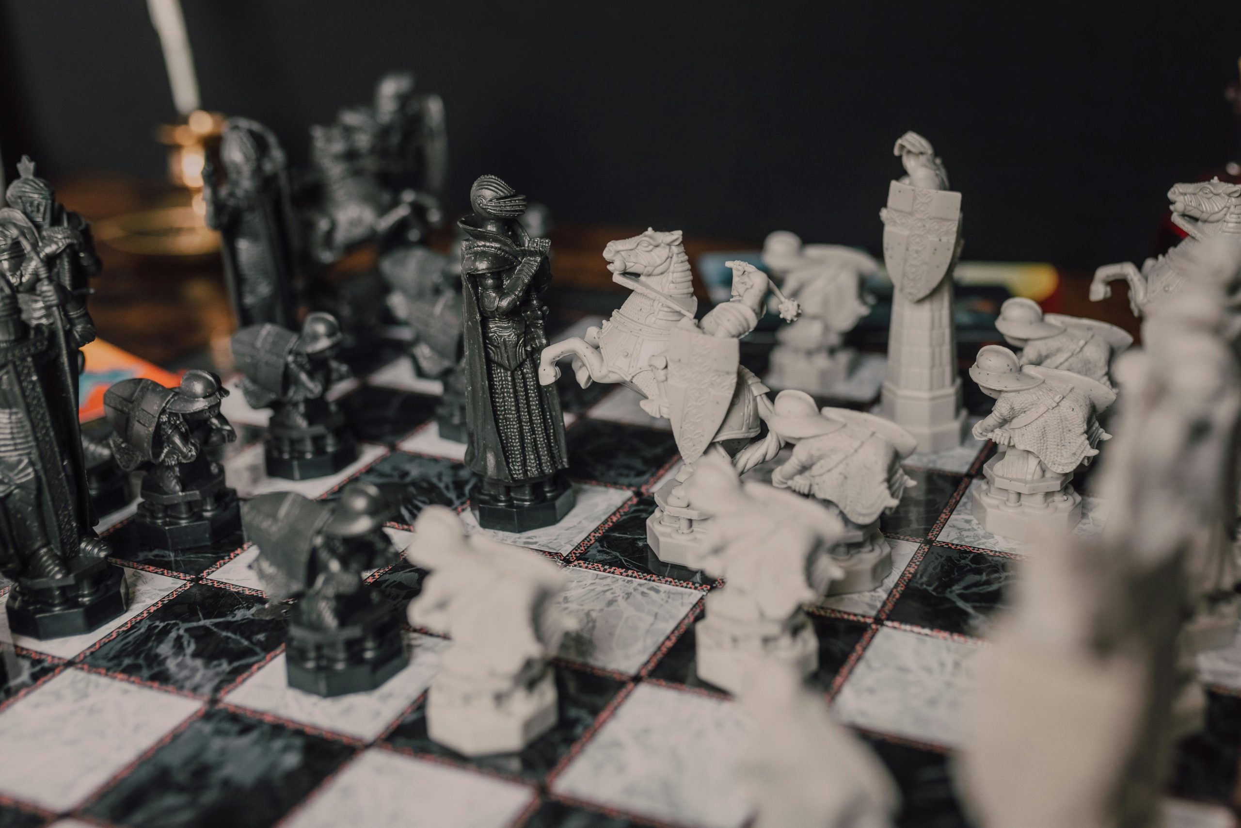 Close-up of ornate chess pieces on a classic marble chessboard, evoking a magical theme.